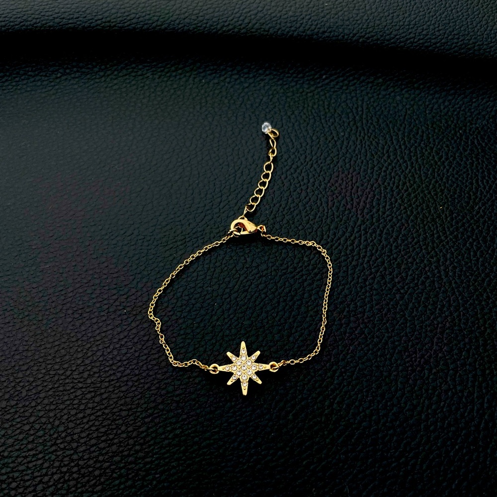 10 karat gold plated over surgical steel with crystals in the star.